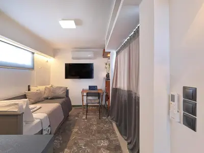 a small living room with a couch and a table at Athens at your feet - Modern Loft with a view in Athens