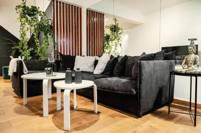 a living room with a black couch and two tables at Novel Acropolis Apartment in Athens