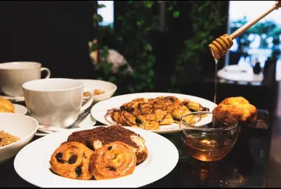 a table with plates of food and cups of coffee at Novel Acropolis Apartment in Athens