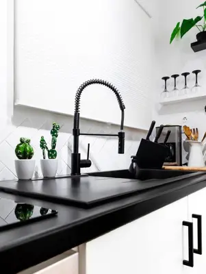 a black kitchen counter with a sink and a sink at Novel Acropolis Apartment in Athens