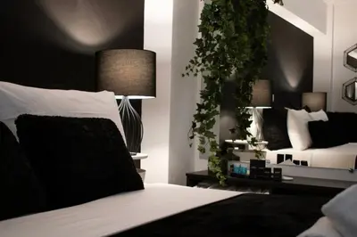 a bedroom with a bed with a plant on the wall at Novel Acropolis Apartment in Athens