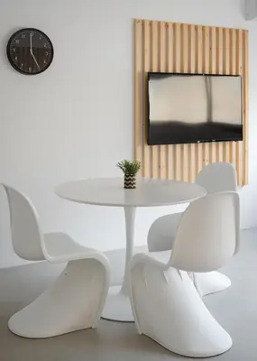 a white table and chairs in a room with a clock at Syntagma Serenity Suites in Athens