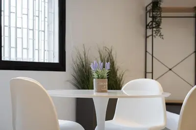 a white table with white chairs and a vase on it at Syntagma Serenity Suites in Athens