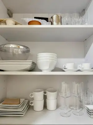 a white shelf with dishes and cups and glasses at Elegant apartment in Kolonaki in Athens