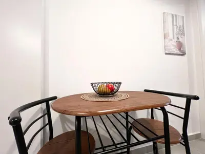 a wooden table with two chairs and a bowl on it at Eva's House - 2 Bedroom Apartment in Athens