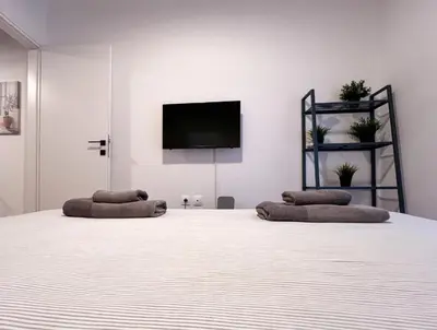 a white room with two beds and a flat screen tv at Eva's House - 2 Bedroom Apartment in Athens