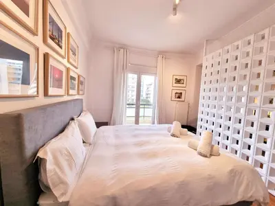a bedroom with a large bed with white sheets at In the Heart of the Center in Athens