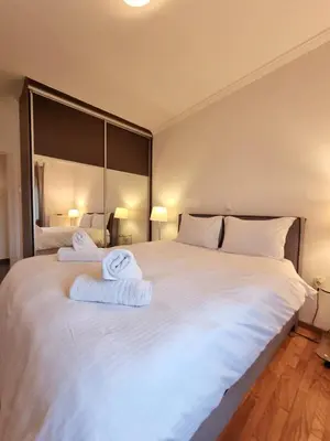 a bedroom with a large white bed with towels on it at In the Heart of the Center in Athens
