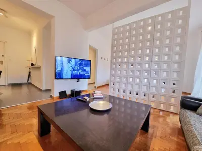 a living room with a table and a large tv at In the Heart of the Center in Athens