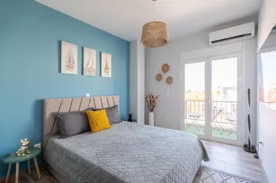 a bedroom with a bed with a blue wall at Glyfada Center Seaview Two Bedrooms in Athens