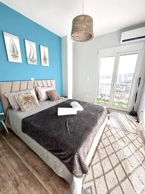a bedroom with a bed and a blue wall at Glyfada Center Seaview Two Bedrooms in Athens