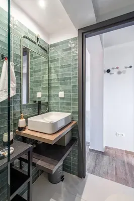 a bathroom with a white tub and green tiles at Glyfada Center Seaview Two Bedrooms in Athens