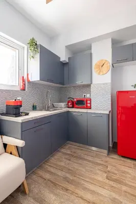 a kitchen with a red refrigerator and gray cabinets at Glyfada Center Seaview Two Bedrooms in Athens