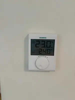 a white clock on a white wall with the time at Martino apartment in Athens