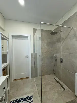 a bathroom with a shower with a glass door at Martino apartment in Athens