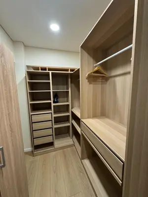 a walk in closet with wooden shelves and cabinets at Martino apartment in Athens