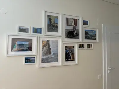 a group of pictures on a white wall at Martino apartment in Athens