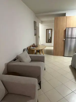 a living room with a couch and a table and a refrigerator at Home4U apt2, just 8Km from airport in Markopoulo
