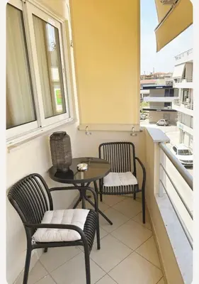 a small table and two chairs on a balcony at Home4U apt2, just 8Km from airport in Markopoulo
