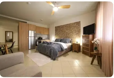 a large bedroom with a bed and a kitchen at Home4U apt2, just 8Km from airport in Markopoulo