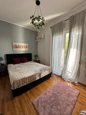 a bedroom with a bed and a chandelier at Melody Apartment in Athens