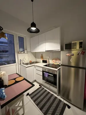 a kitchen with a stainless steel refrigerator and a table at Melody Apartment in Athens