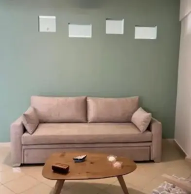 a living room with a couch and a coffee table at Home4U apt1, just 8Km from airport in Markopoulo