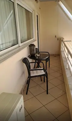 a balcony with a table and chairs in a room at Home4U apt1, just 8Km from airport in Markopoulo