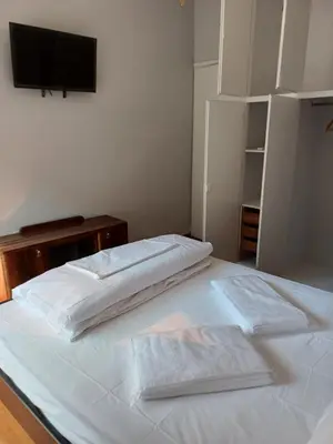 a bedroom with two beds and a television on the wall at Acropolis view in Lycabettus in Athens