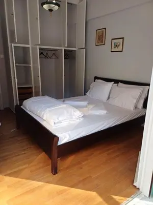 a bed with white sheets and pillows in a room at Acropolis view in Lycabettus in Athens
