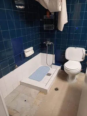 a blue tiled bathroom with a toilet and a shower at Acropolis view in Lycabettus in Athens