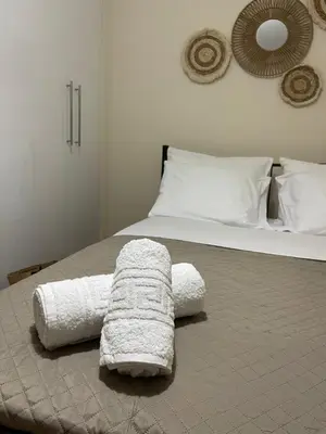 a bed with a white blanket laying on it at Modern Studio in Palaio Faliro in Athens