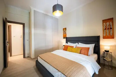 a bedroom with a large bed with orange and yellow pillows at Central 2 Bdrm Aprt In Koukaki! in Athens