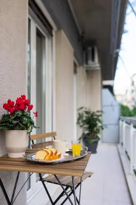 a table with a plate of food on a balcony at Central 2 Bdrm Aprt In Koukaki! in Athens