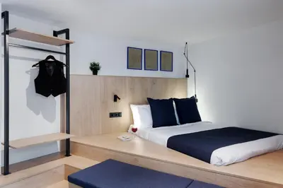 a bedroom with a king sized bed with blue pillows at MoRe by Zoia Living in Athens