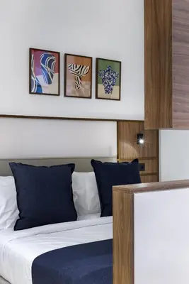 a bedroom with a bed with four pictures on the wall at MoRe by Zoia Living in Athens