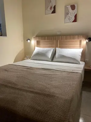 a bedroom with a large bed with white sheets and pillows at Athens Ellinikon Apartment in Athens