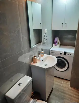 a bathroom with a sink and a washing machine at Athens Ellinikon Apartment in Athens