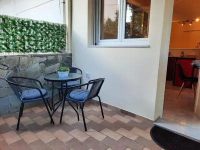 a table and chairs in a patio with a window at Athens Ellinikon Apartment in Athens