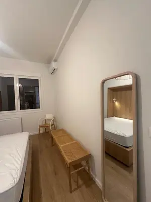 a small room with a bed and a mirror at YPSILON Apartment in Athens