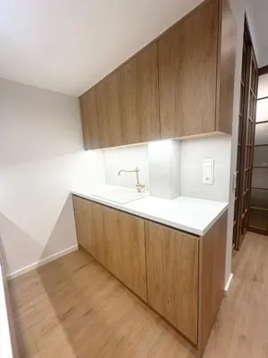 a kitchen with a sink and wooden cabinets at YPSILON Apartment in Athens
