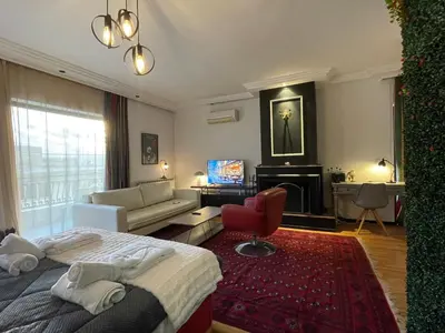 a bedroom with a bed and a couch and a television at Konstantinia comfort studio in Athens