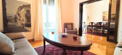 a living room with a table and a couch at Grand suite in the temple of Zeus in Athens