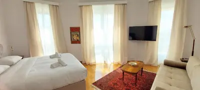 a bedroom with a bed and a couch and a tv at Grand suite in the temple of Zeus in Athens