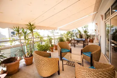 an outdoor patio with chairs and tables and plants at Μεγάλο Διαμέρισμα με ευρύχωρο μπαλκόνι στην Αθήνα in Athens