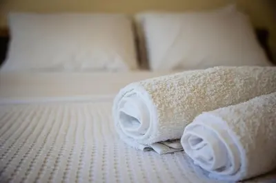 a stack of rolled towels on a bed at Μεγάλο Διαμέρισμα με ευρύχωρο μπαλκόνι στην Αθήνα in Athens