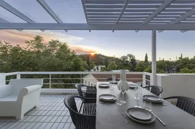 a table and chairs on a balcony with a view at Spacious 3bdr Apartment with Monumental View in Athens
