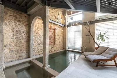 a pool in a room with a couch and a chair at Asomaton by Oniro in Athens
