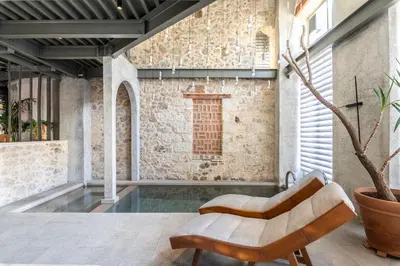 an indoor pool with a chair in front of a brick wall at Asomaton by Oniro in Athens