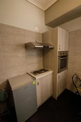 a small kitchen with a stove and a refrigerator at Bright small penthouse in the center of athens in Athens